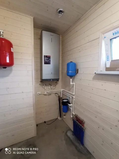 Настенный котёл и коллектор отопления в деревянной котельной
